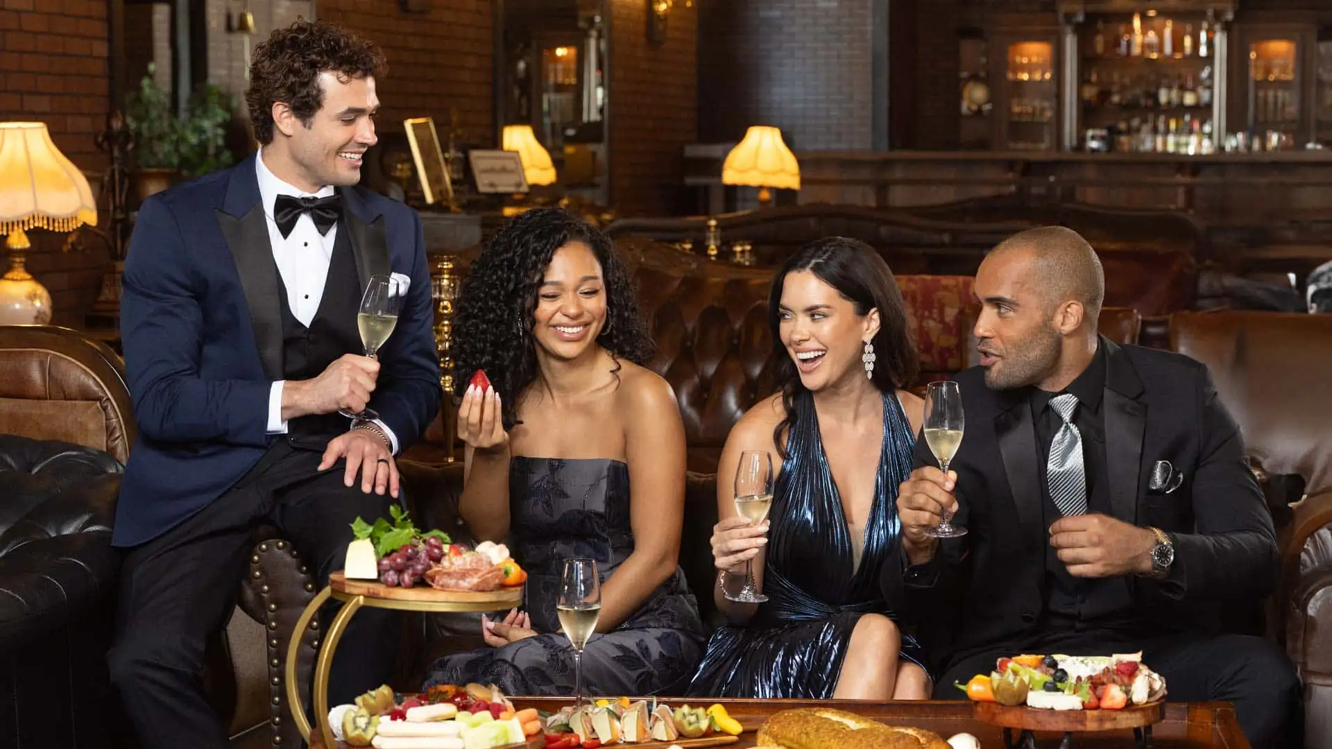 A group of friends well dressed in tuxedos and dresses happy celebrating with champagne