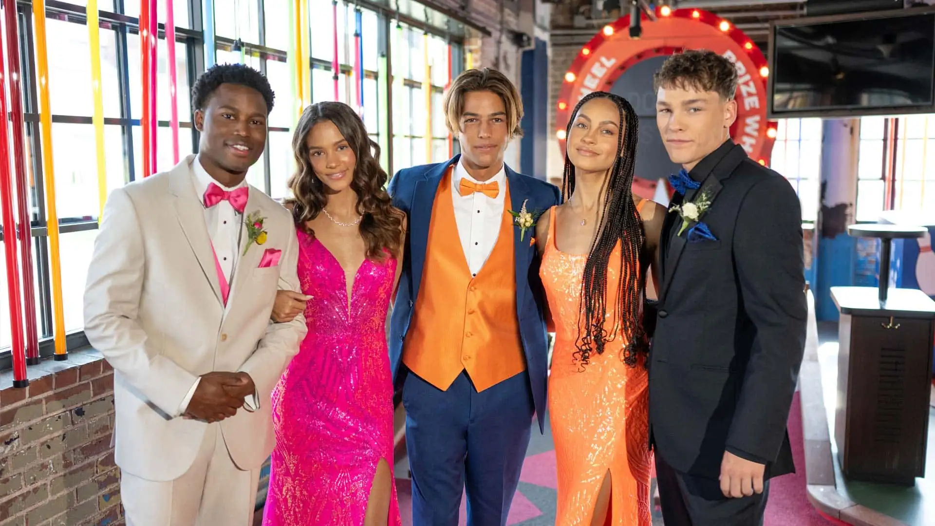 A group of teens with vibrant tuxedos and dresses in prom