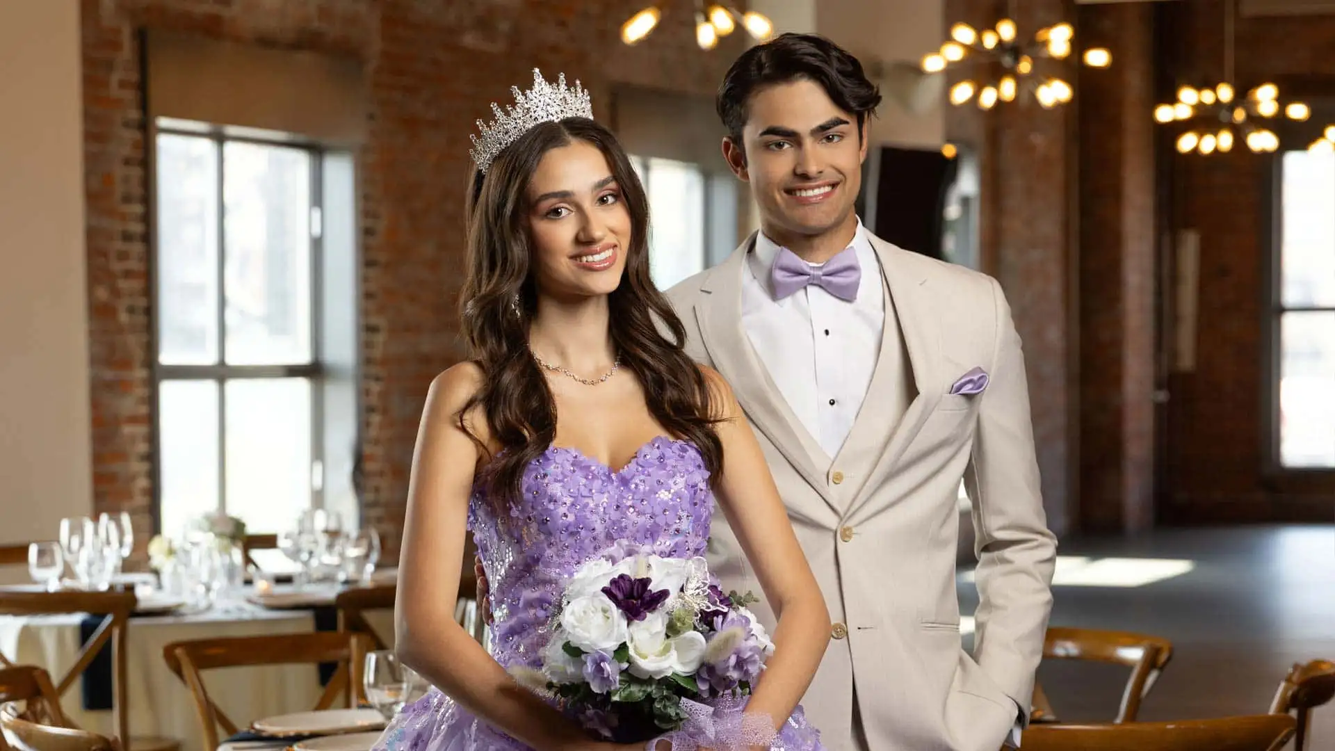 Two teenagers smiling and posing for a photo at a quinceañera celebration.